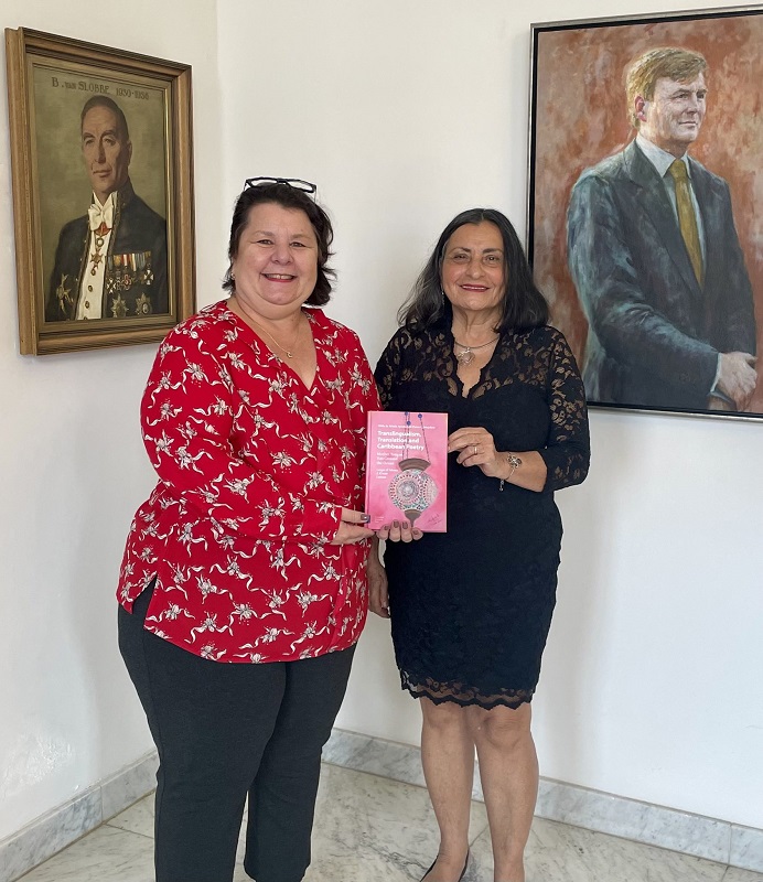 Hilda Ayoubi offers her book to acting governor of Curaçao